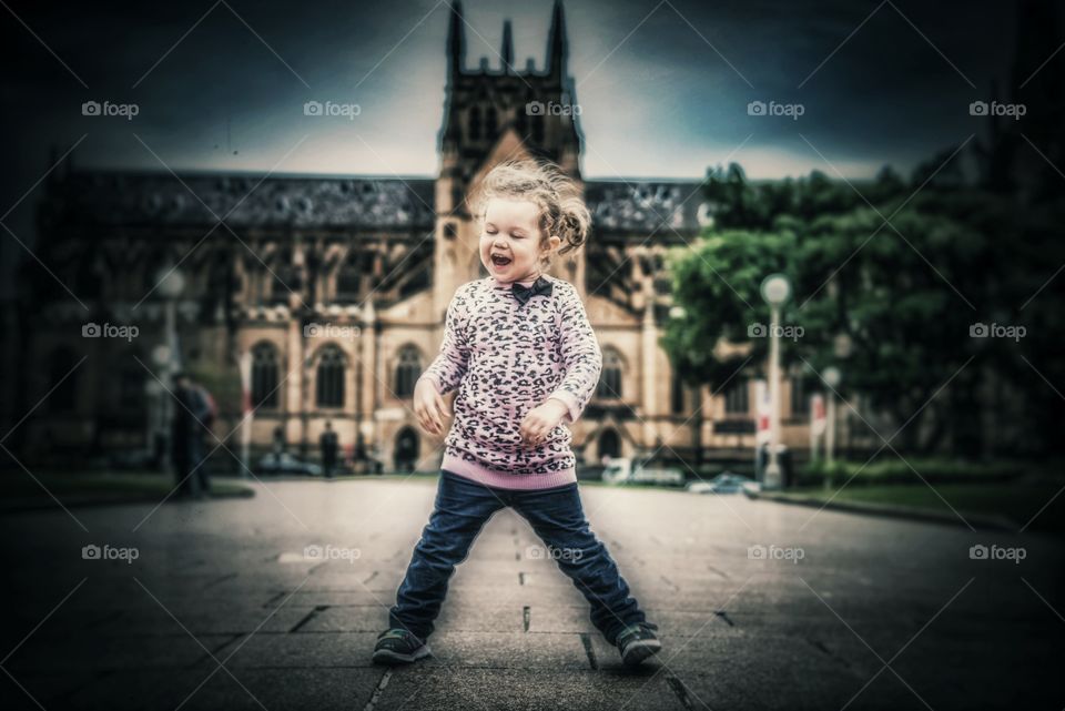 Cute happy girl standing in front of building