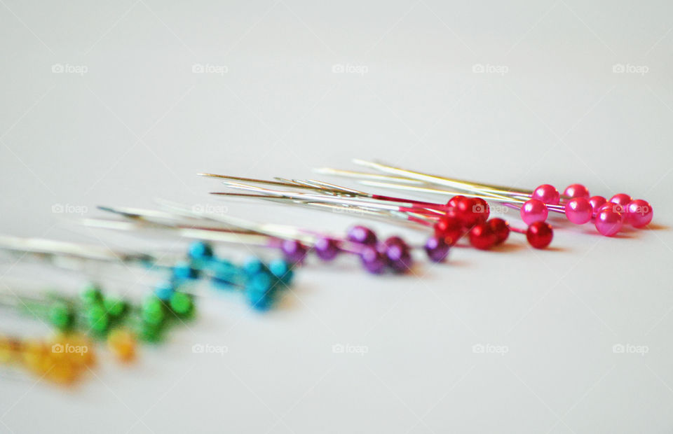 Multi colored thumbtacks on white background