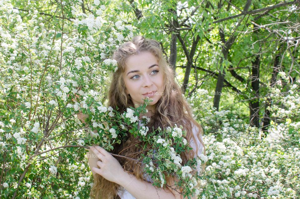 Portrait of Beautiful Young Girl on Flowers Background