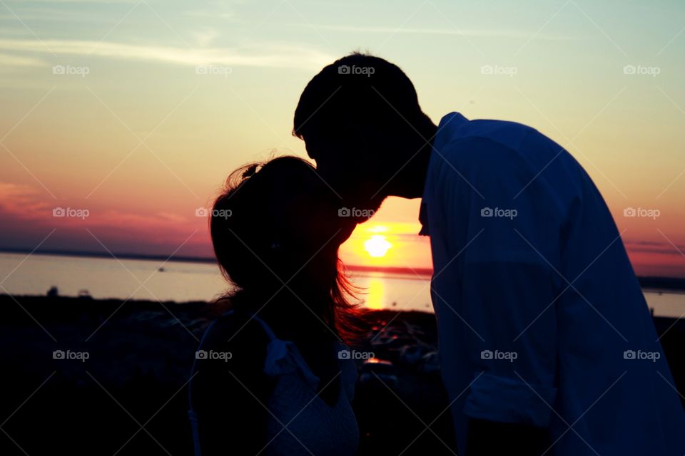 newlyweds sharing sunset kiss