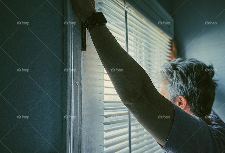 Woman at window, woman looks out window, mystery woman looks out blinds of window, neighborhood watch, looking for trouble, watching outside, facing the window, blinds and windows 