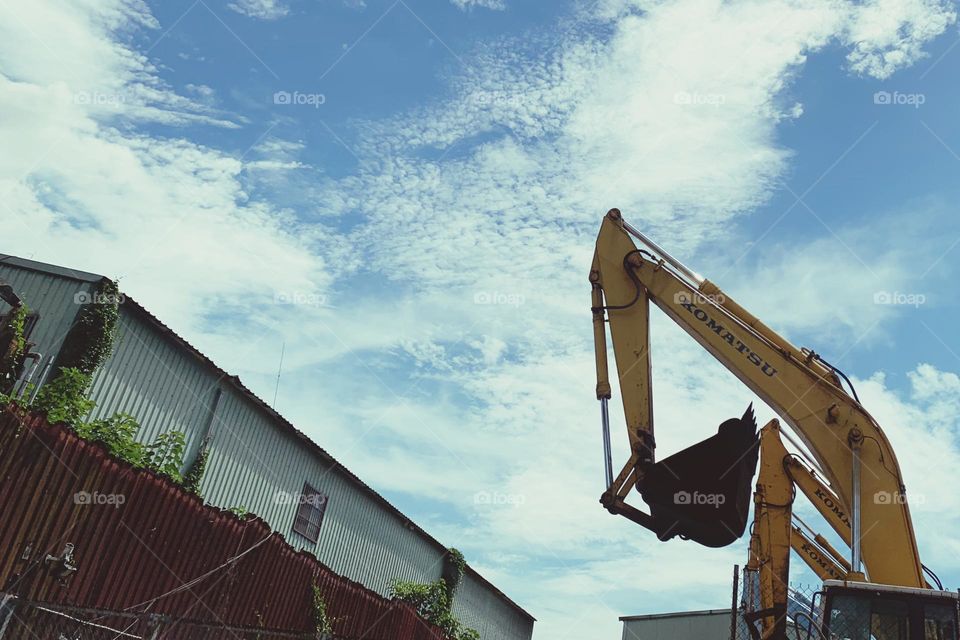 Excavator by a house in the daylight