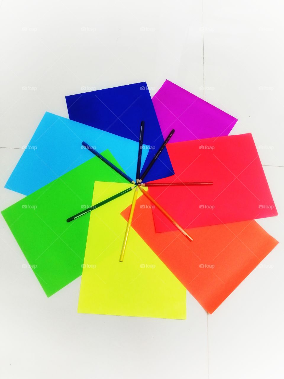 Colored papers and pencils in circular design.