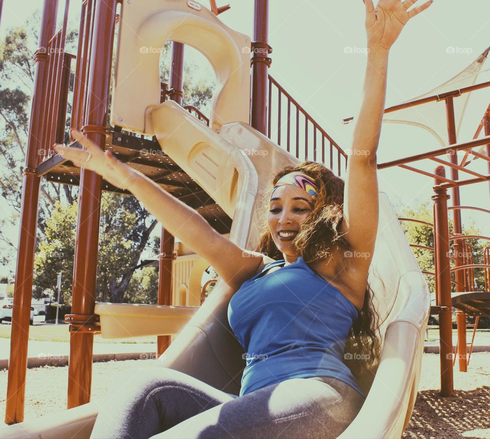 Enjoying the inner child as she slides down the slide