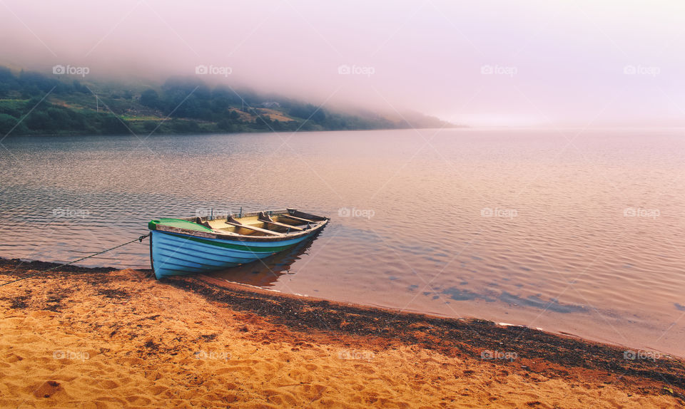 Blue wooden fishing boat on sandy beach at Loch Na Fooey in county Mayo, Ireland