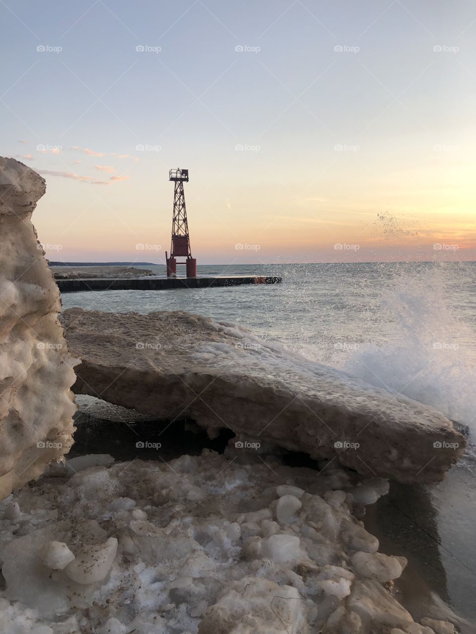Sunset at Lake Michigan, waves against iceberg 