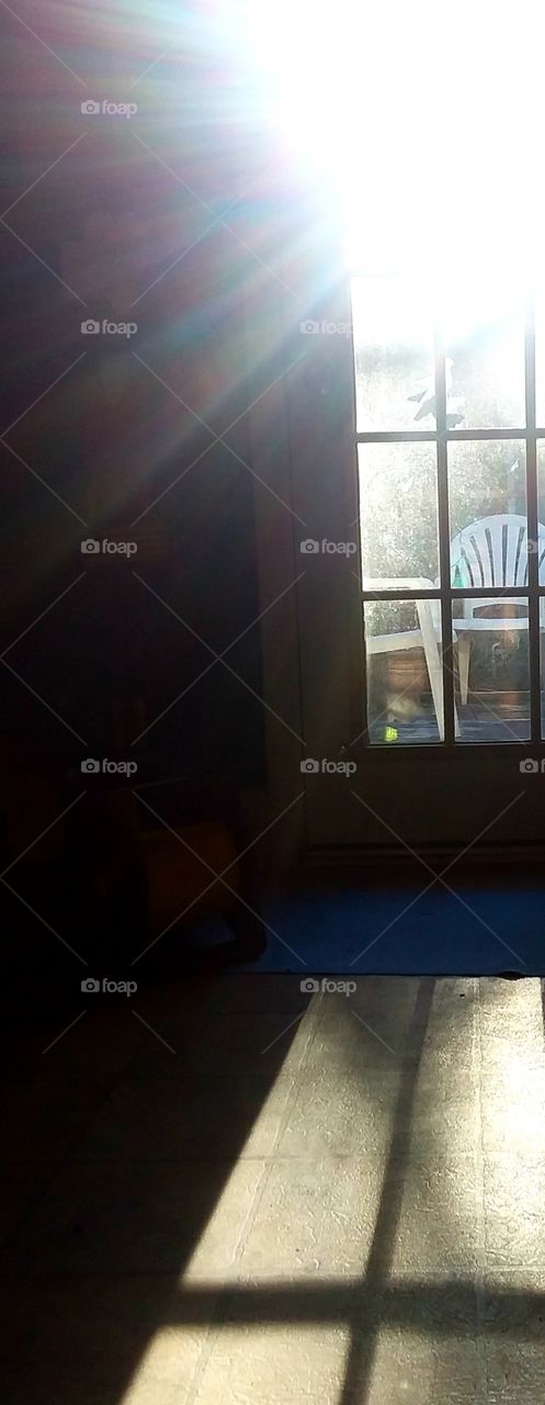 sunset shines through the window casting its colorful sunrays throughout the room