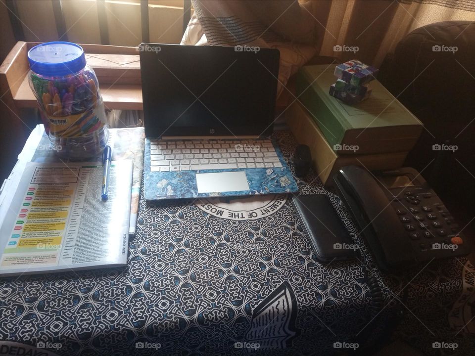 laptop,books,pens,power bank,ear pod, Rubik cube and a landline