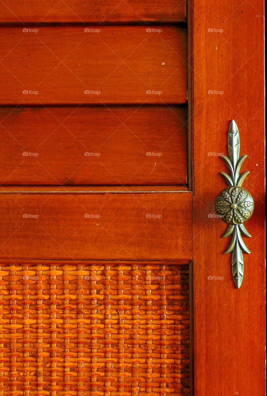 Random photo of a unique door handle on a TV cabinet.