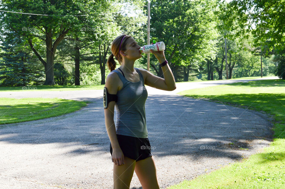 Woman drinking after a run at the park