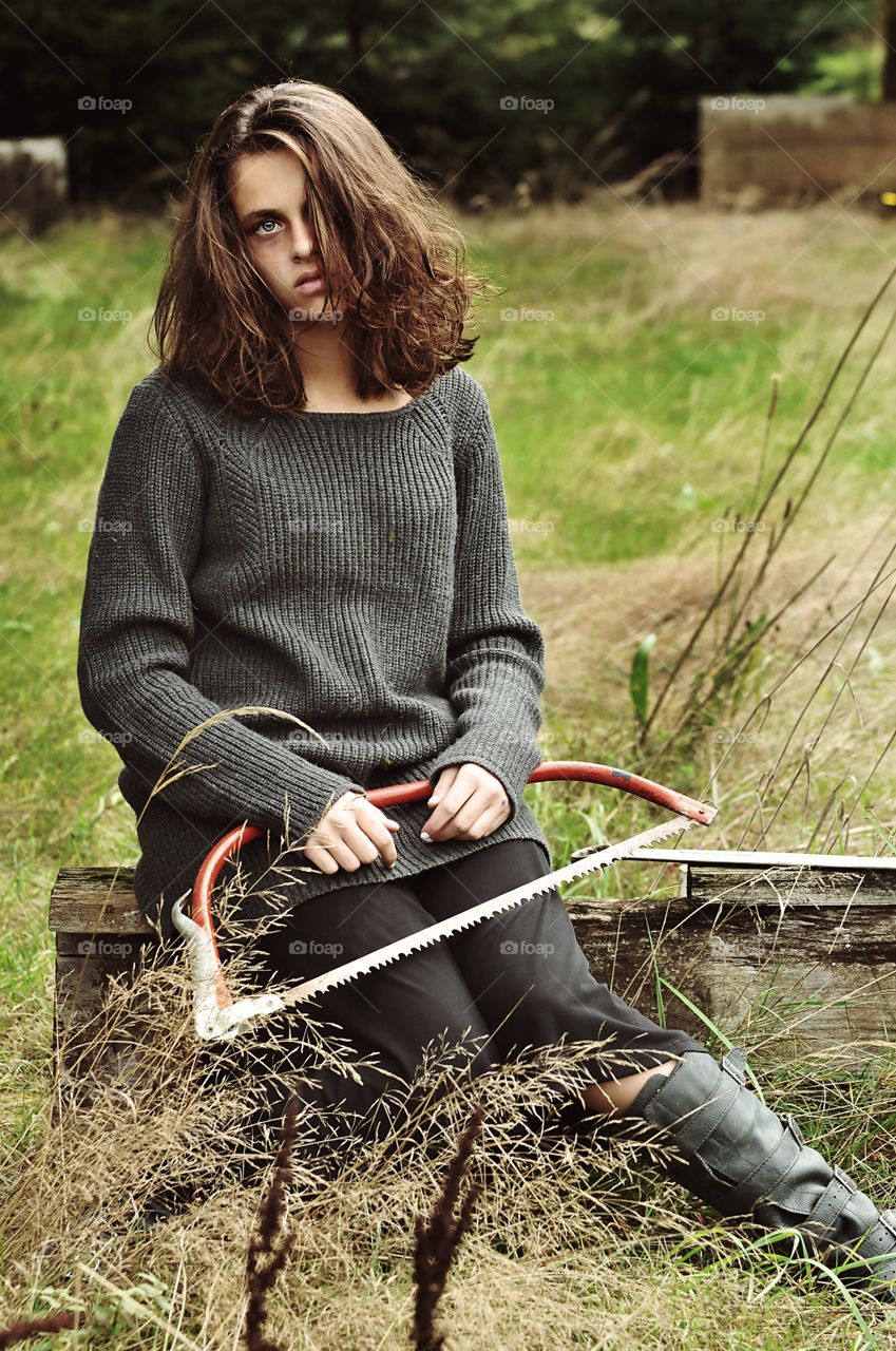 Woman sitting with hacksaw in hand