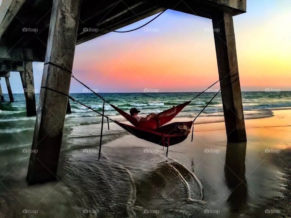 Relaxing hammock style under a pier
