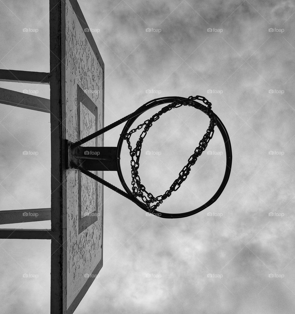 An amazing black and white shot of an old basketball net in a school yard captured from underneath