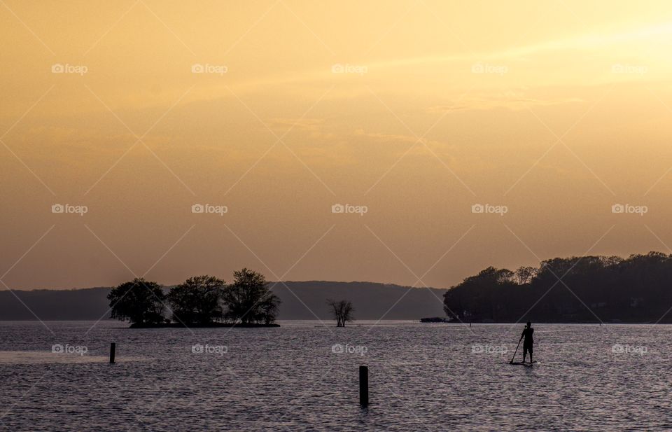 Wake boarder on Pewaukee lake in Wisconsin at sunset