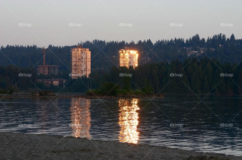 Port Moody Sunset in the East. Sunset reflections off twin towers Port Moody, BC Canada, sunset reflecting into buildings, buildings reflecting onto ocean