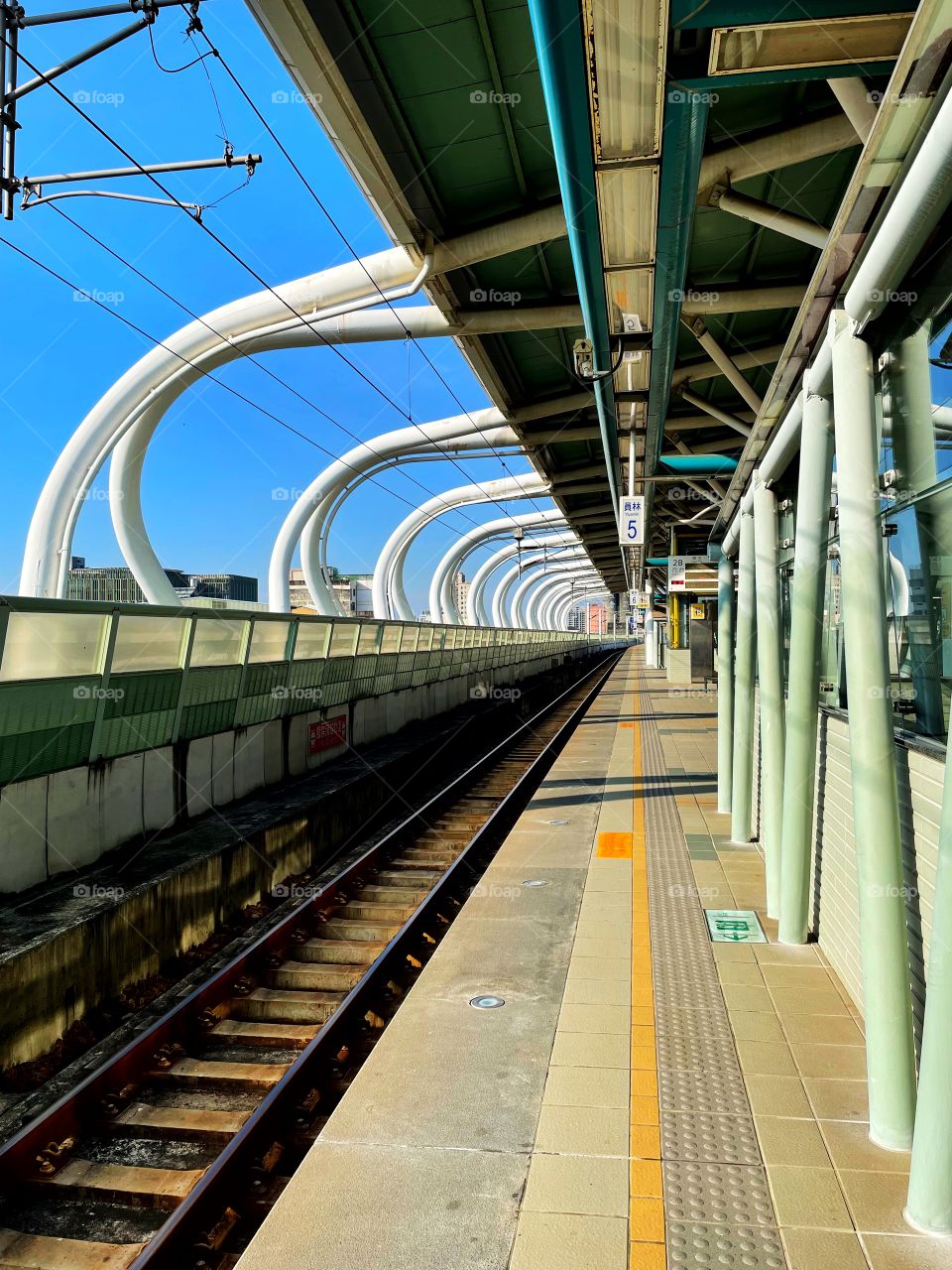 Train tracks platform 5 in Yuanlin city, Taiwan. The station is empty, and the arches come above the train tracks. 