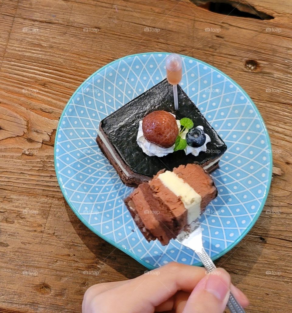 Chocolate cake with whipped cream, strawberries and blueberries paired with dropper wine