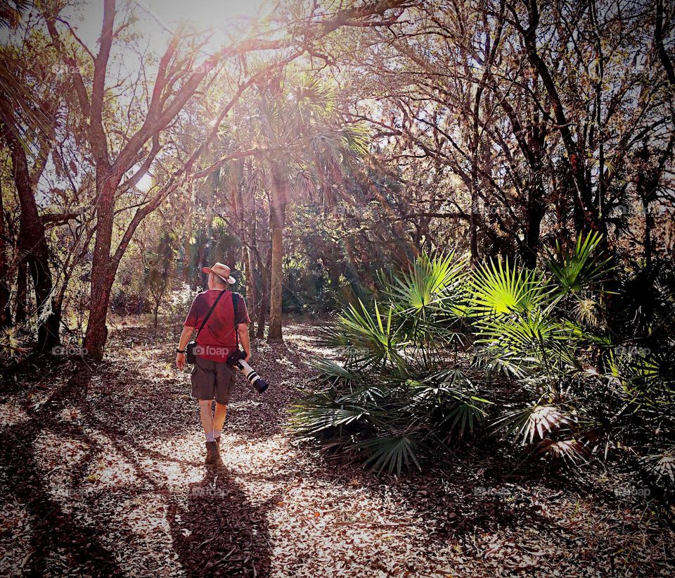 Rainbow sunbeams on a photographer in the woods.