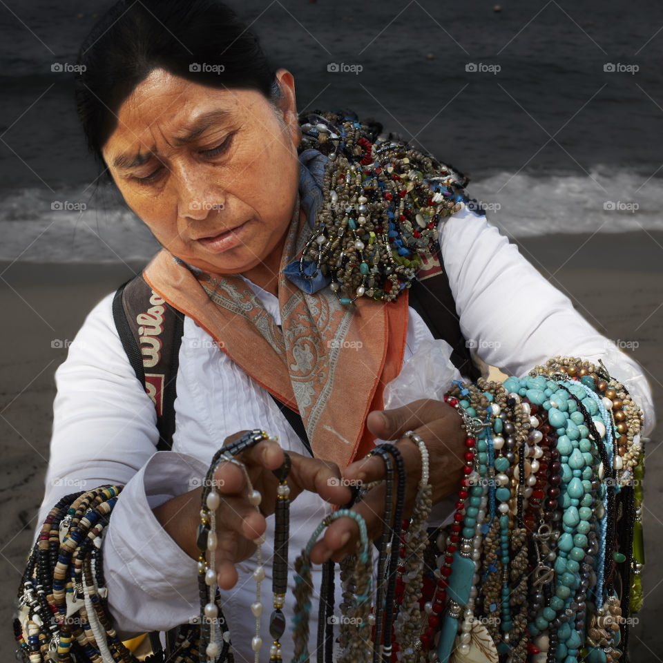 Women selling jewelry In Mexico . Mexican woman selling beaded jewelry on beach. 