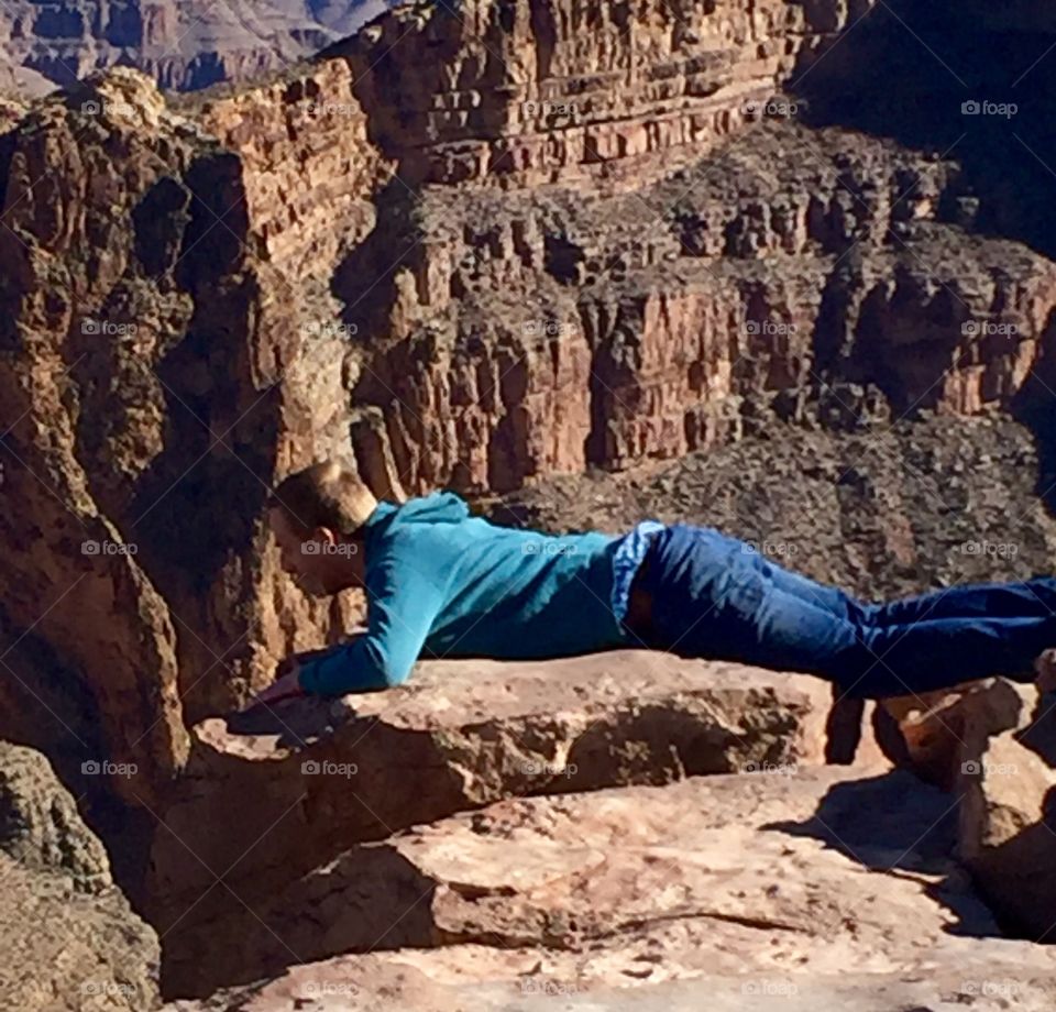 Man lying at the edge of the Grand Canyon 