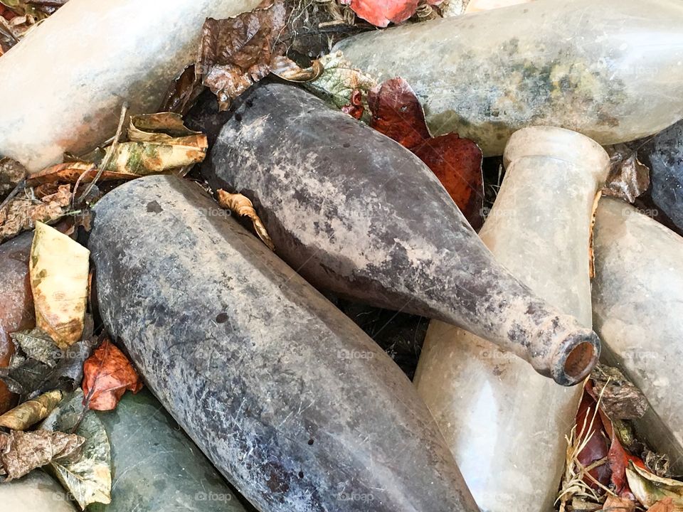 Freshly dug up antique vintage glass collectable bottles dirty grungy cobwebs 