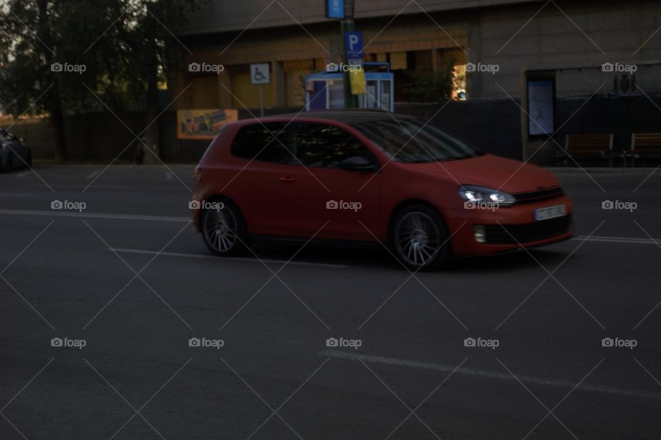 A red car going on about its day in this busy world.