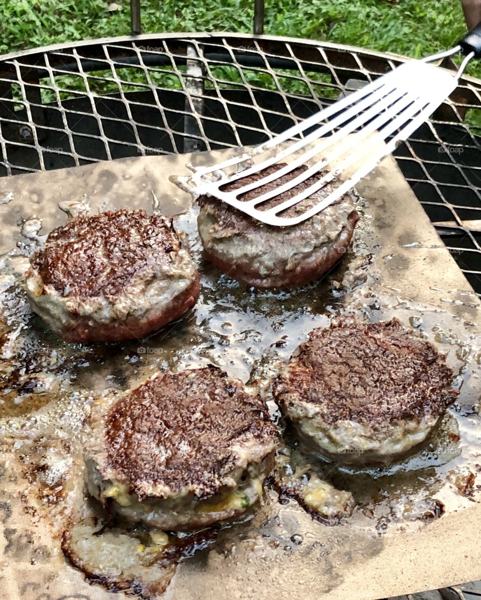 Double fresh jalapeños and cheddar cheese stuffed homemade hamburgers, sizzling fragrantly on the cowboy grill. 
