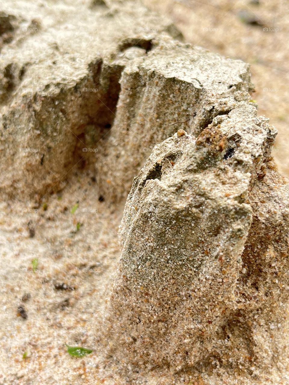 It is sandy soil that has been eroded by water.