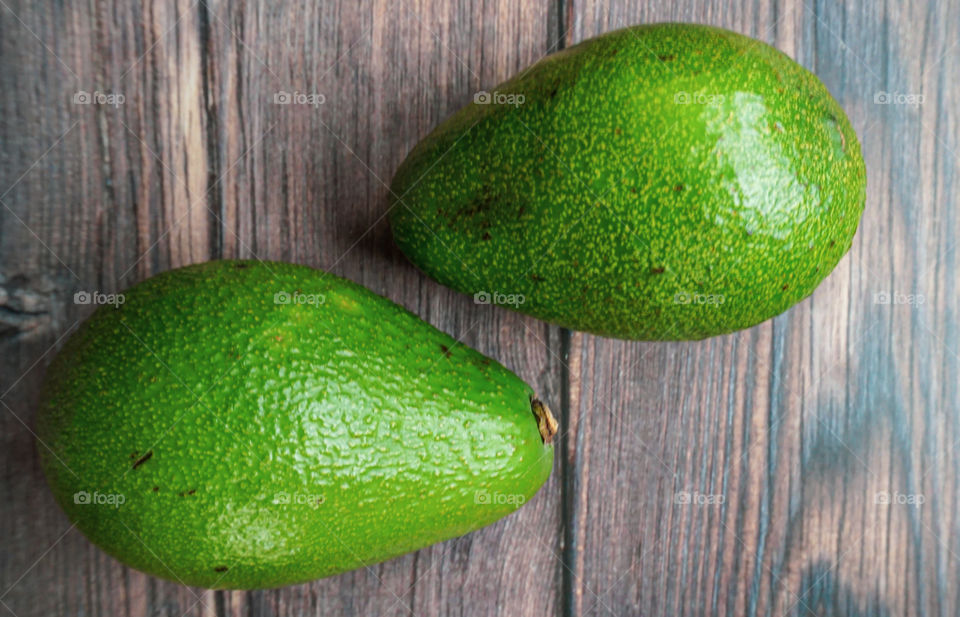 green avocado on wooden background