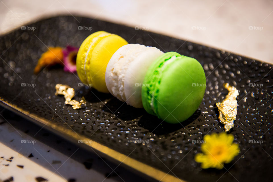 Three round macaroons in yellow white and green for shapes circles and ellipses