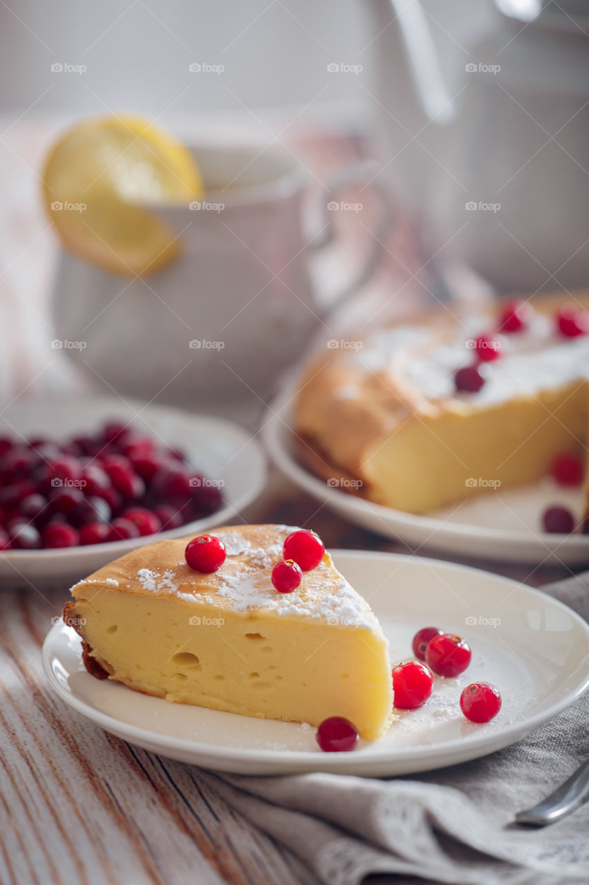 Cheesecake with cranberries and sugar on wooden background