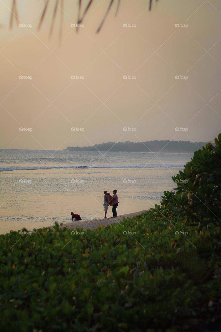 parents playing on the beach with their children
