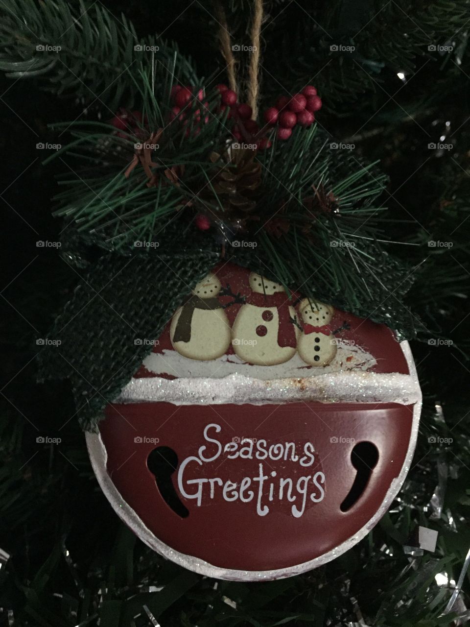 Christmas ornament that says season greetings with snowmen on it