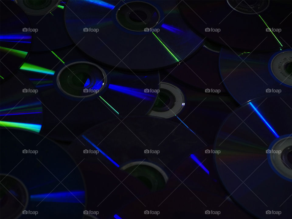 CDs iluminados emanando distintos rayos de colores