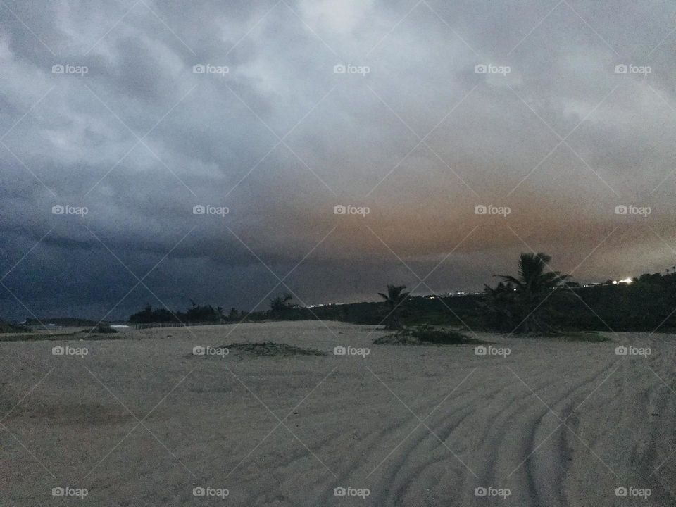 Storm clouds over beach at sunset