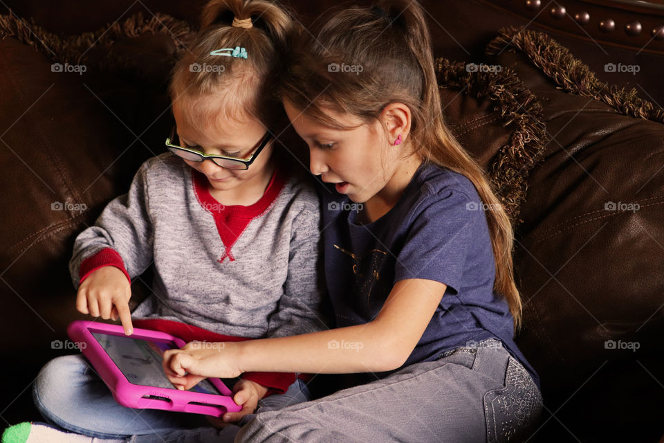 Sisters playing on a tablet together