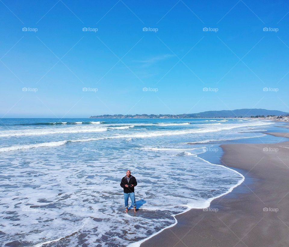 enjoying the beach on a sunny day as the waves crash against my feet
