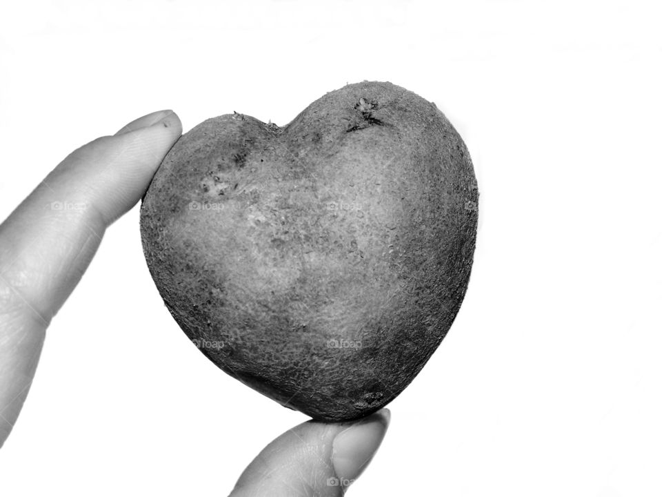 Hand holding heart shaped potato