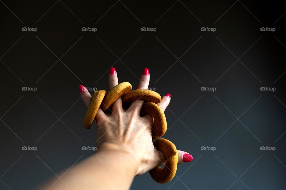 butter cookie on fingers of woman hand