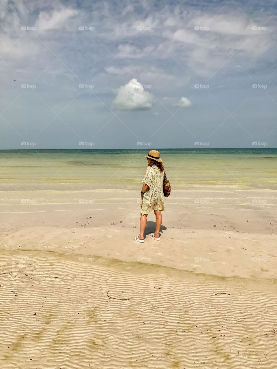 A beautiful woman takes in the stunning ocean in Punta Mosquito, Holbox Island.