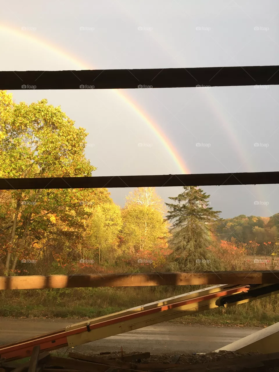 Double rainbow in Cochranton, PA through barn walls of a historic barn being torn down