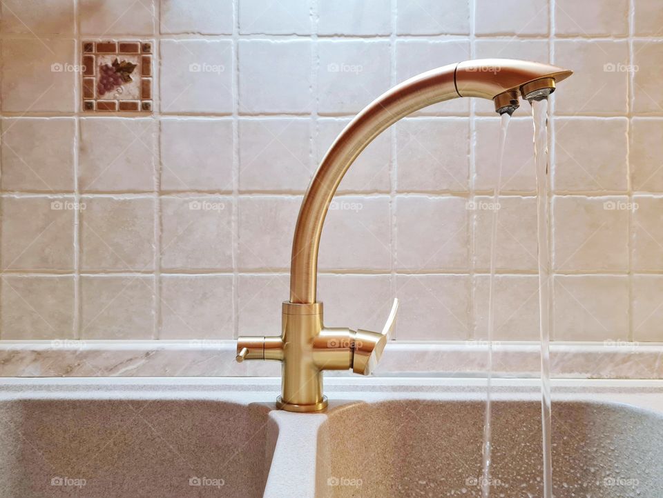 three way bronze colored kitchen faucet connected to a purifier