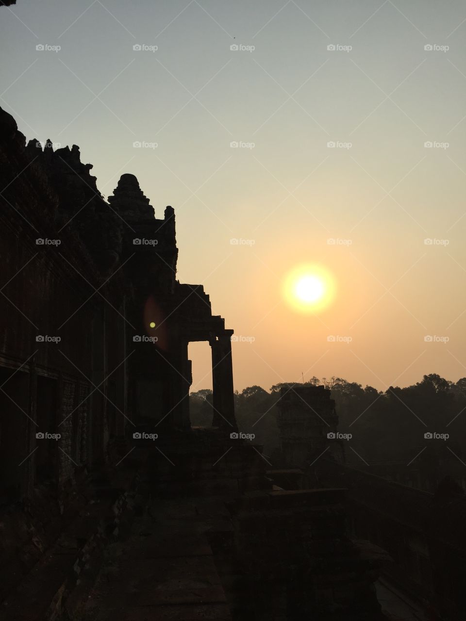 Sunrise at the Angkor Wat temple in Cambodia. Silhouette picture of the architecture and the sun in the background. 