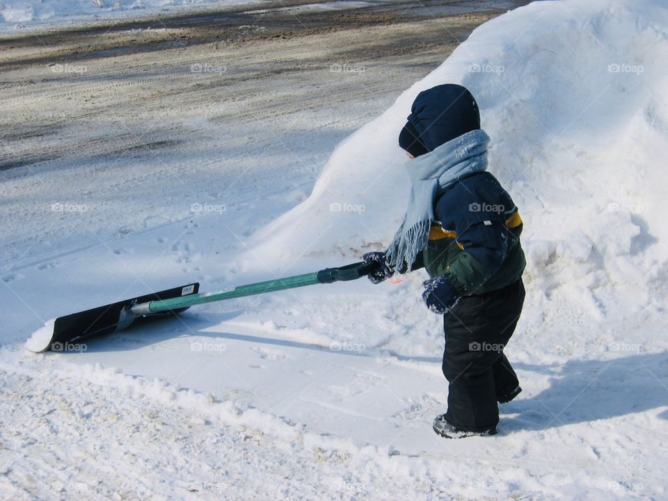 Darling little boy playing out in the fresh fallen snow fall on a cold winter day! 