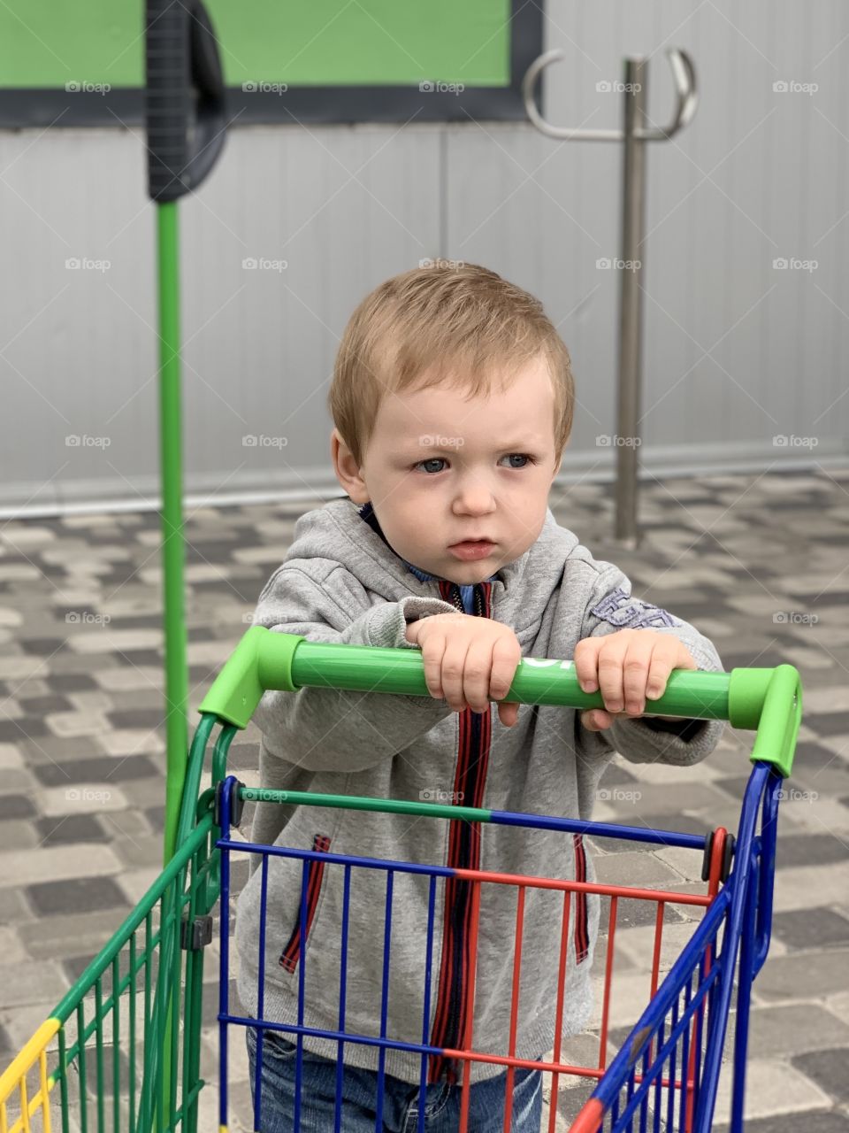 Little boy with supermarket stroller 