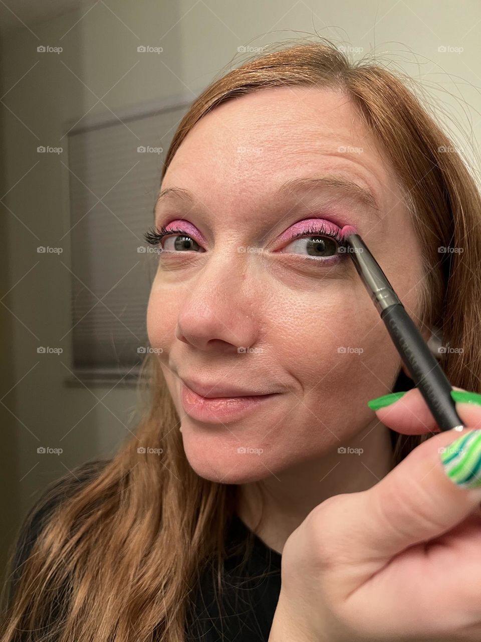 Putting on pretty, bright magenta eyeshadow 