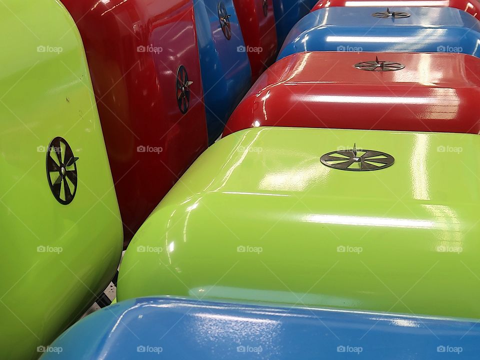 Rows of bright charcoal BBQ’s painted green, red, and blue help prepare for the fun days of summer. 