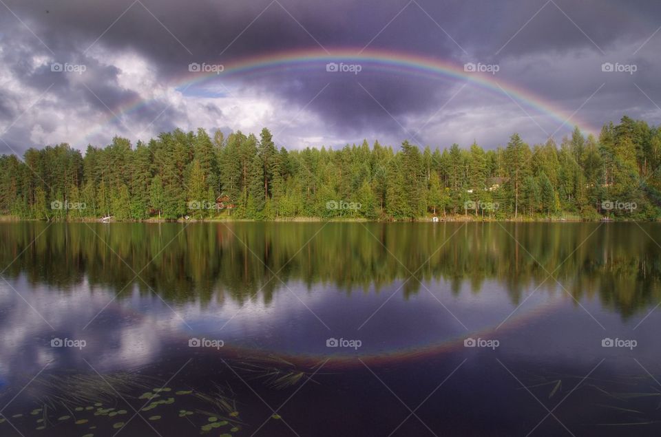 Reflection of rainbow in lake
