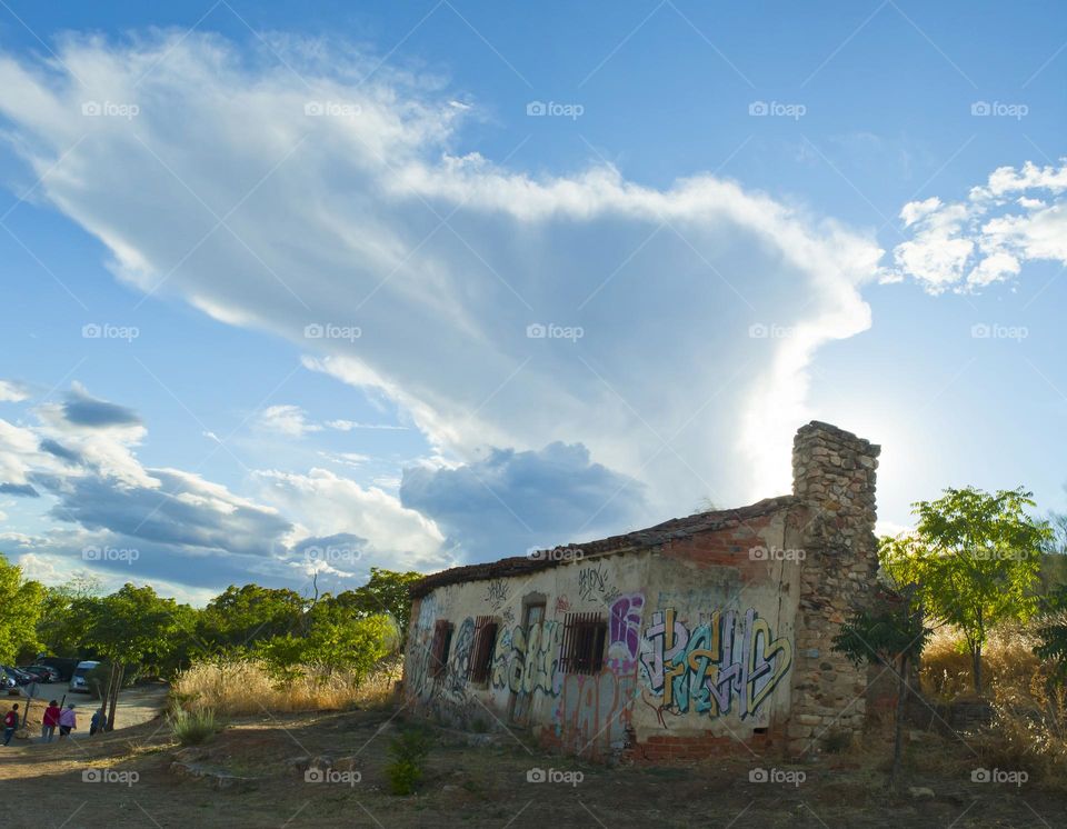 Abandoned building with graffity and thunderstorm behind