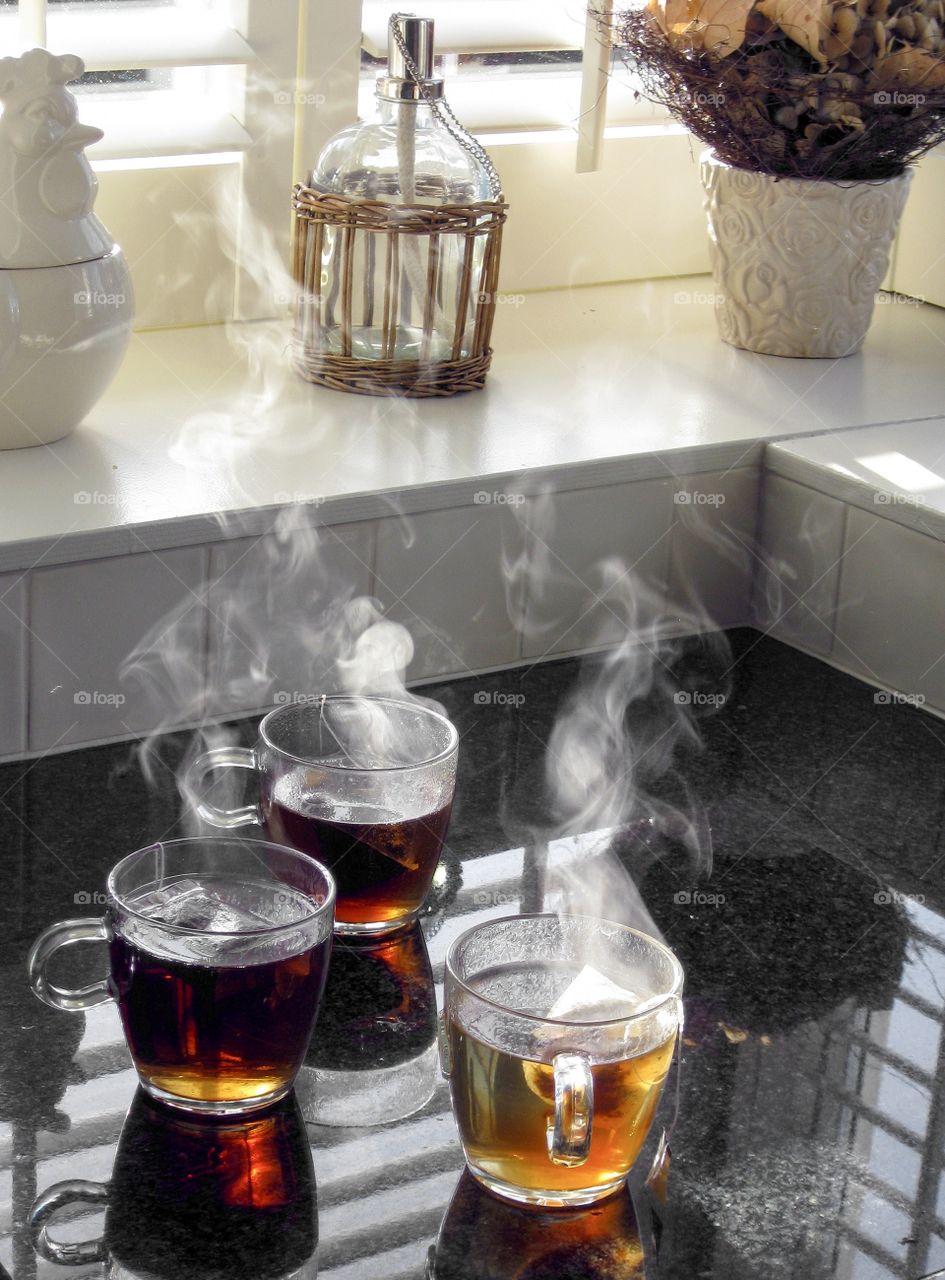 Steaming hot cup of black tea with tea bag